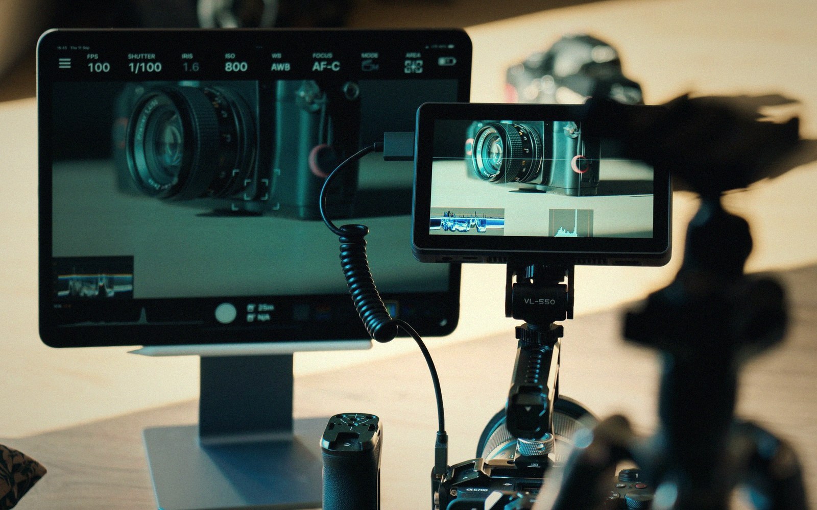 A camera lens image displayed on a tablet screen and an external monitor connected by cable